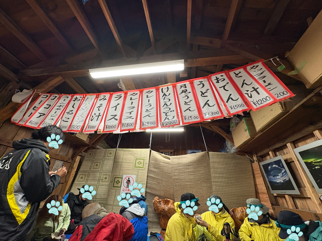 富士山山頂のモニュメントとうっすら光る朝日