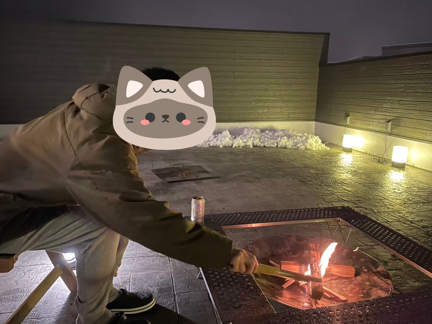 焚き火の薪を火ばさみで調整しているところ