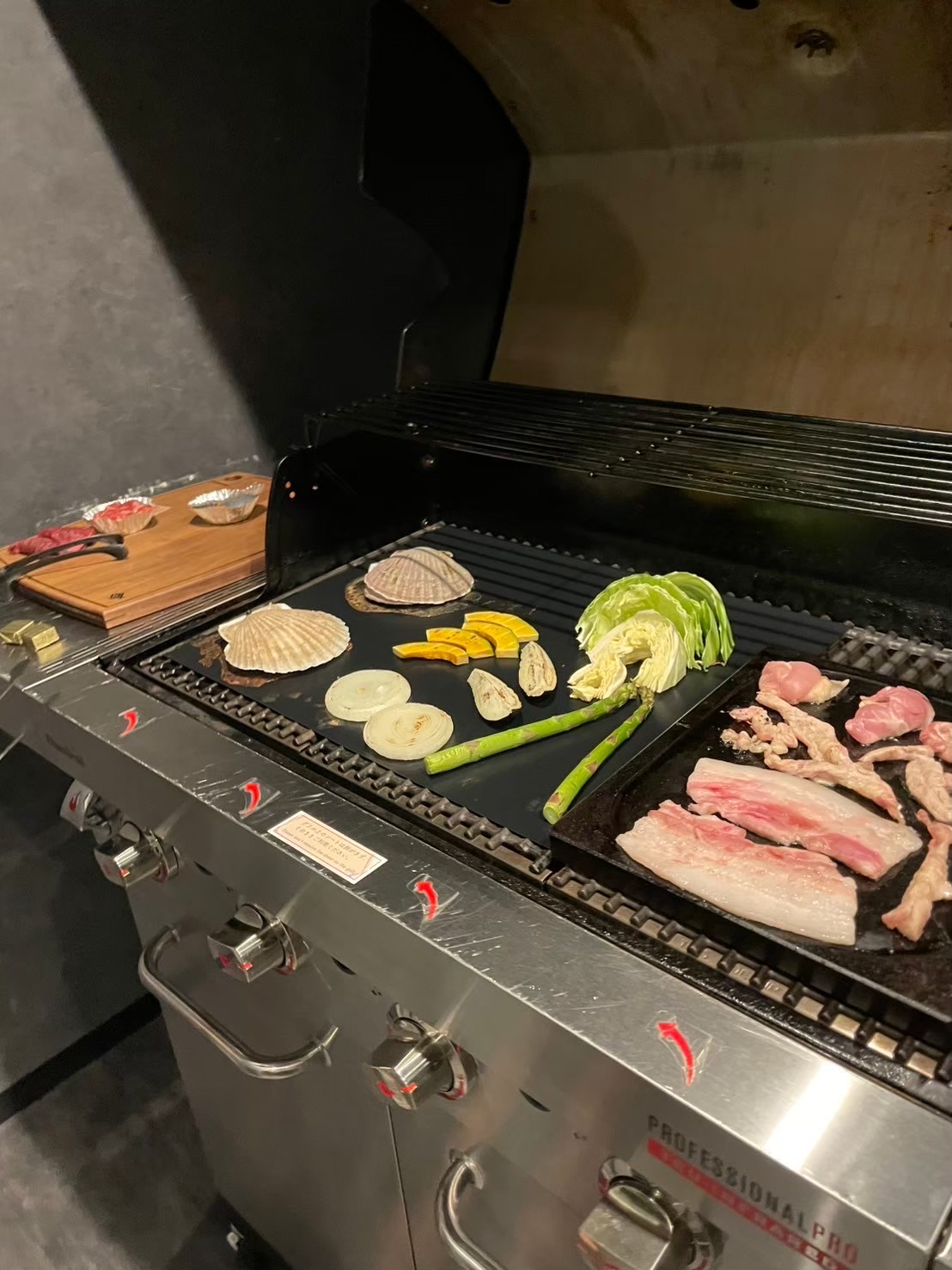 グリルで焼いているホタテと野菜、豚バラ肉