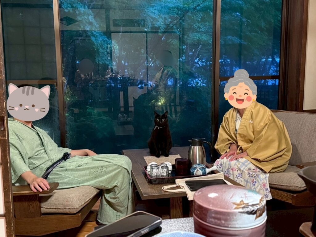 窓辺のテーブルに座る湯楽亭の黒猫